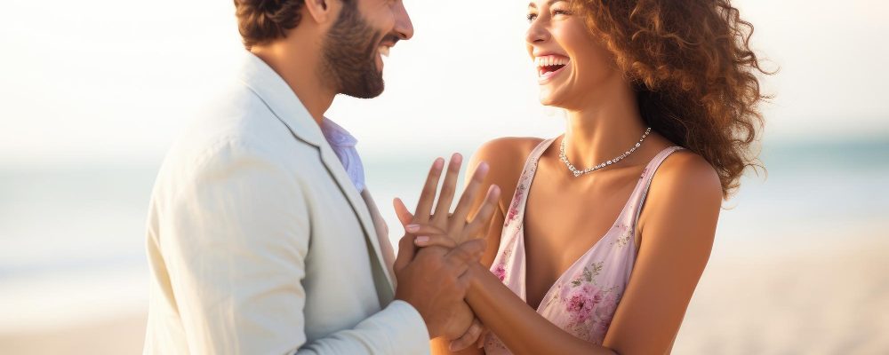 Pareja sonriente con el anillo de compromiso en la playa.